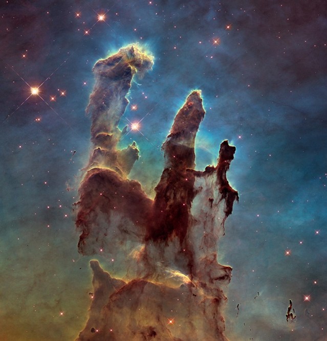 NASA's Hubble Space Telescope has revisited the famous Pillars of Creation, revealing a sharper and wider view of the structures in this visible-light image. Astronomers combined several Hubble exposures to assemble the wider view. The towering pillars are about 5 light-years tall. The dark, finger-like feature at bottom right may be a smaller version of the giant pillars. The new image was taken with Hubble's versatile and sharp-eyed Wide Field Camera 3. NASA/ESA/The Hubble Heritage Team (STScI/AURA)